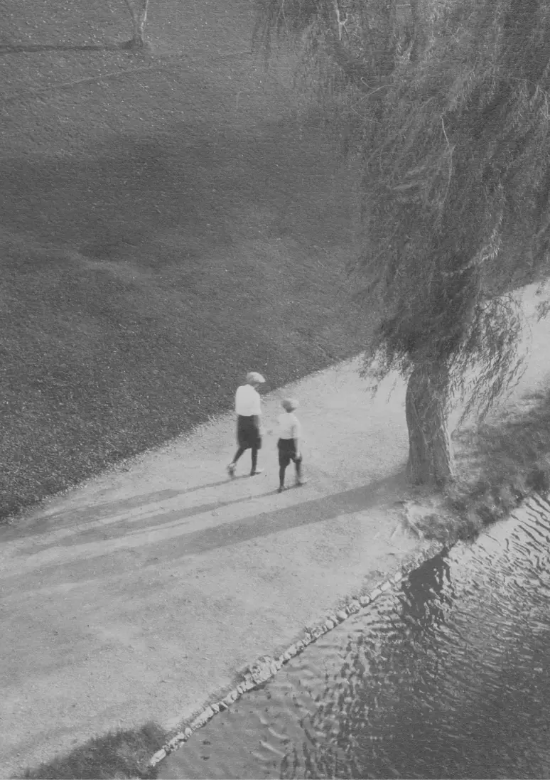 Photo en noir et blanc mettant l’accent sur une femme et un enfant de loin.